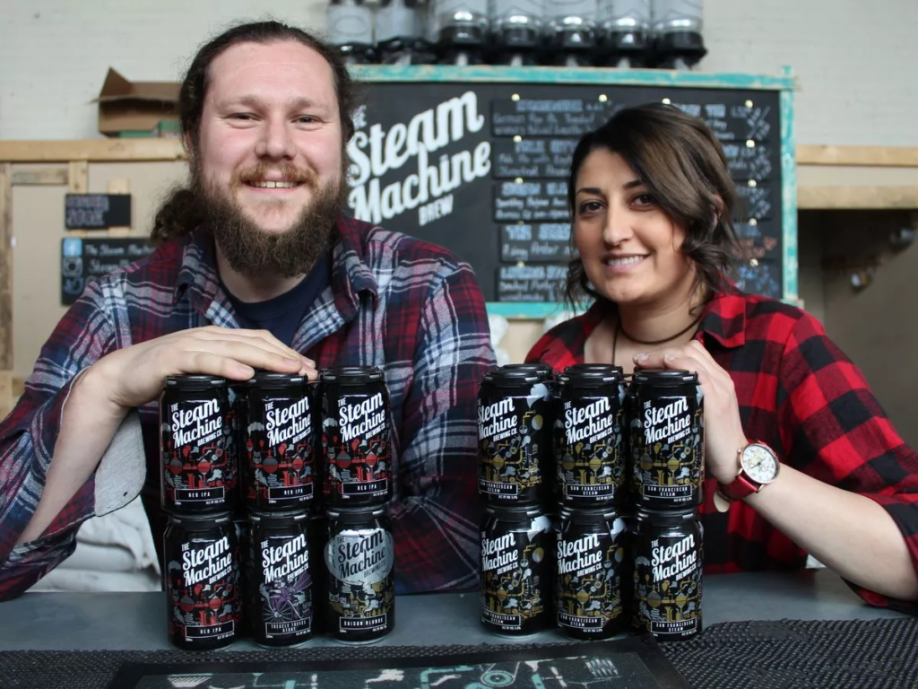 Man and woman holding cans of beer in their hands