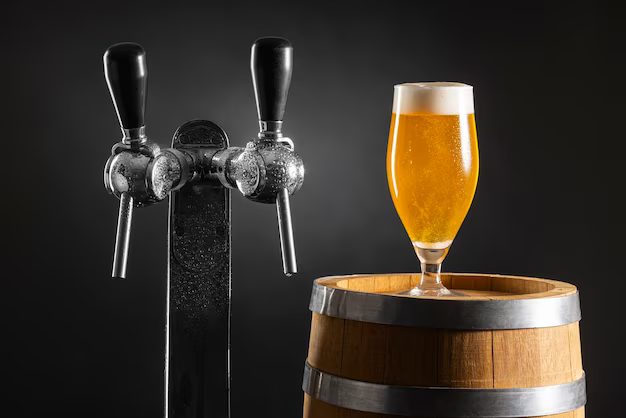 Glass of beer on a barrel next to the bottling machine