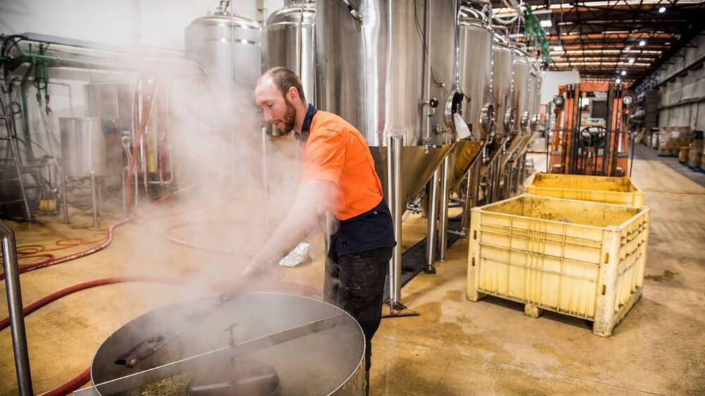 A man prepares beer in a steam barrel